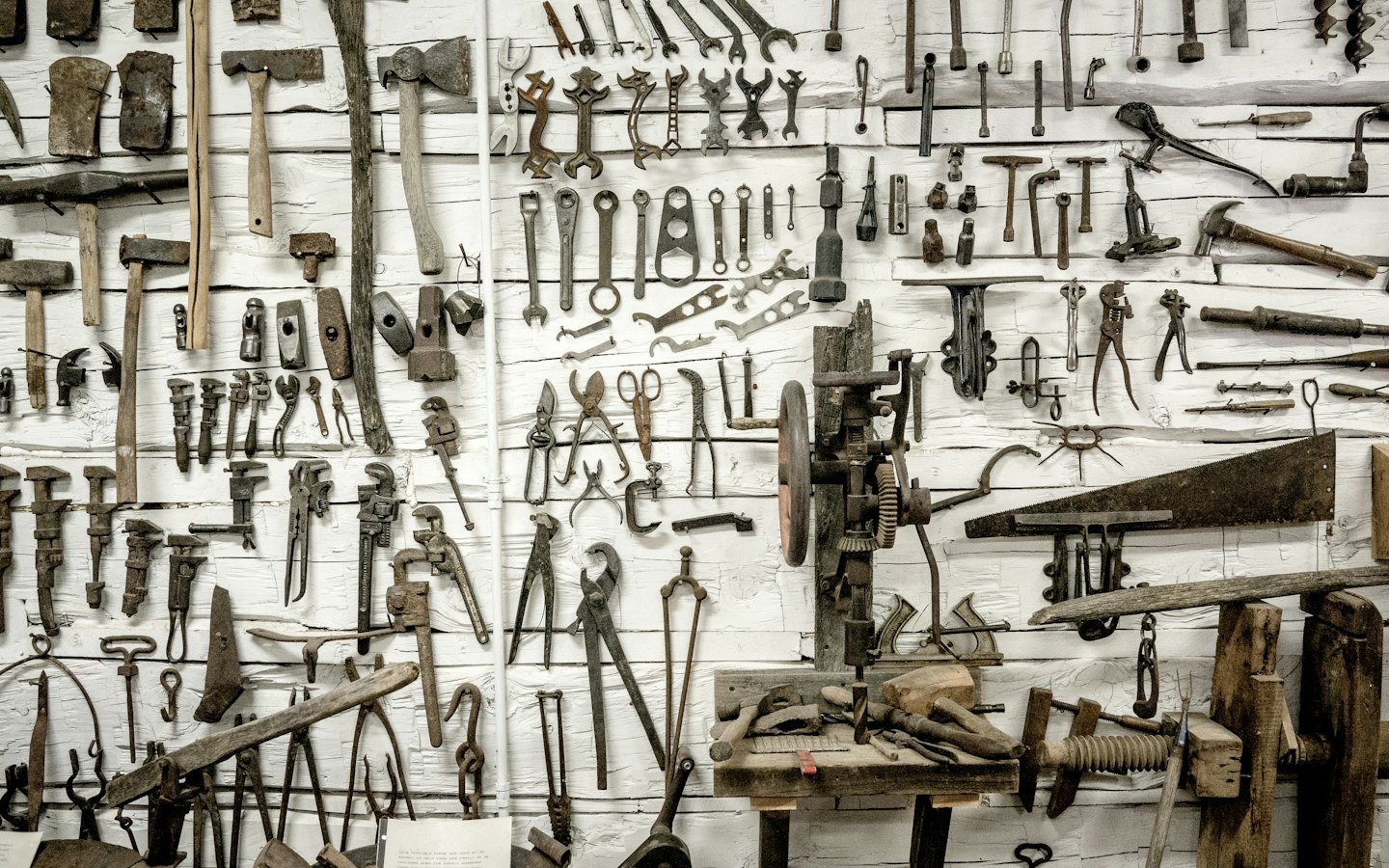 Collection of vintage hand tools on a wooden wall.